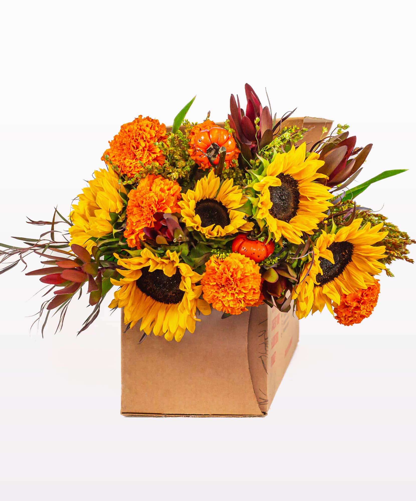 Vibrant bouquet of sunflowers, marigolds, and autumn accents in a rustic box.